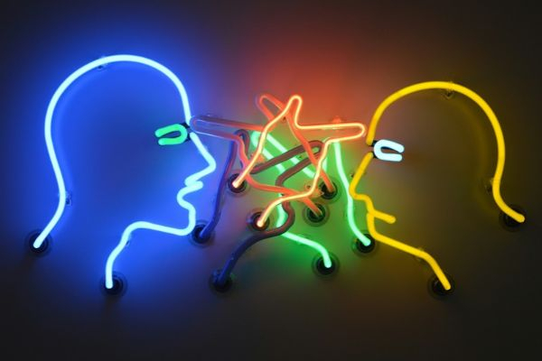 Zwei Köpfe aus bunten Neonröhren.